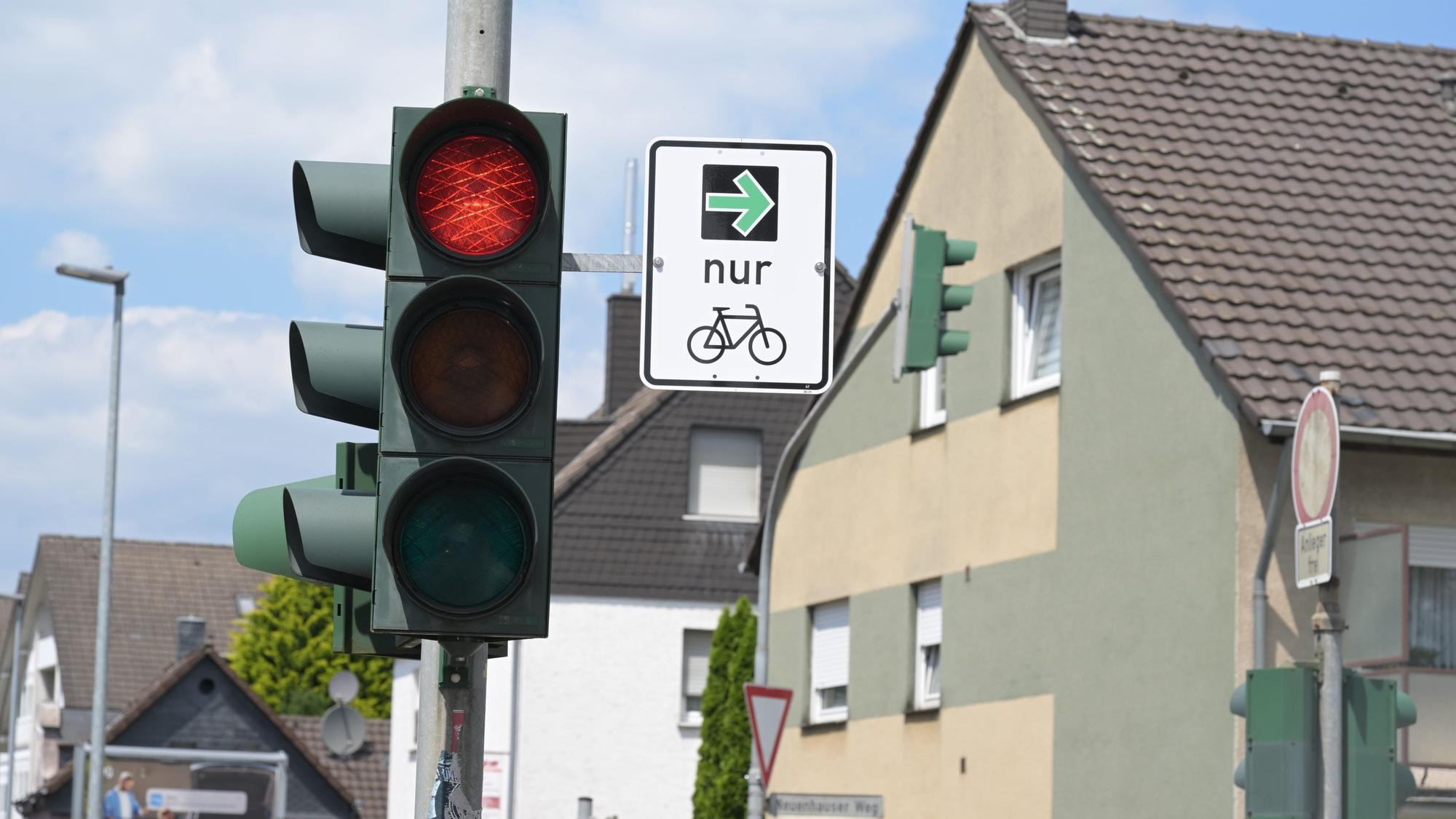 An einem Ampelmast hängt das Verkehrsschild mit dem grünen Pfeil