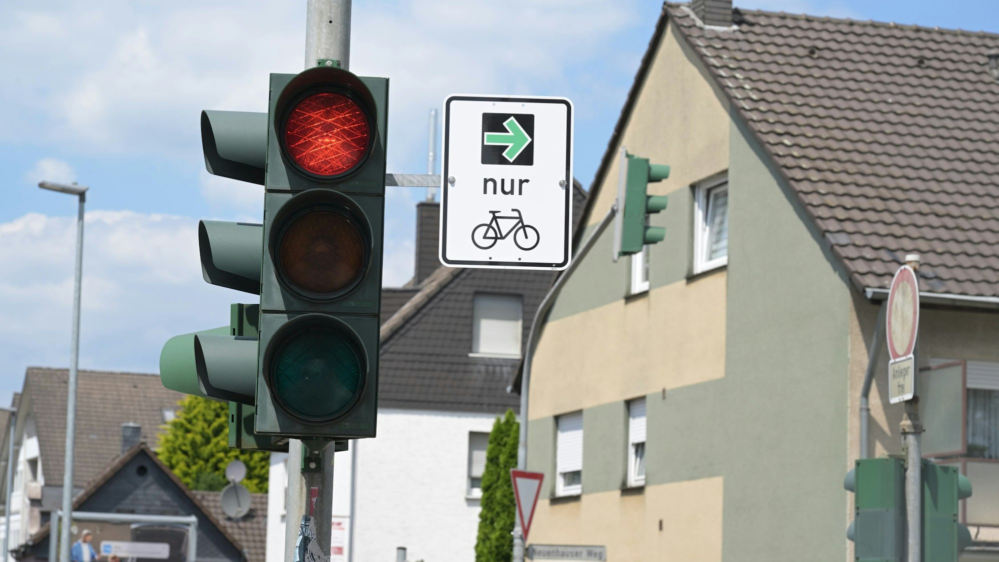 An einem Ampelmast hängt das Verkehrsschild mit dem grünen Pfeil