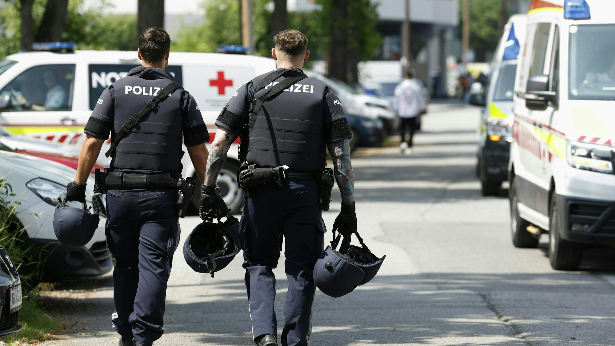 Einsatzkräfte gehen in der Nähe des Tatorts. Ein Polizei-Großeinsatz ist in einer Grazer Schule in der Dreierschützengasse angelaufen.
