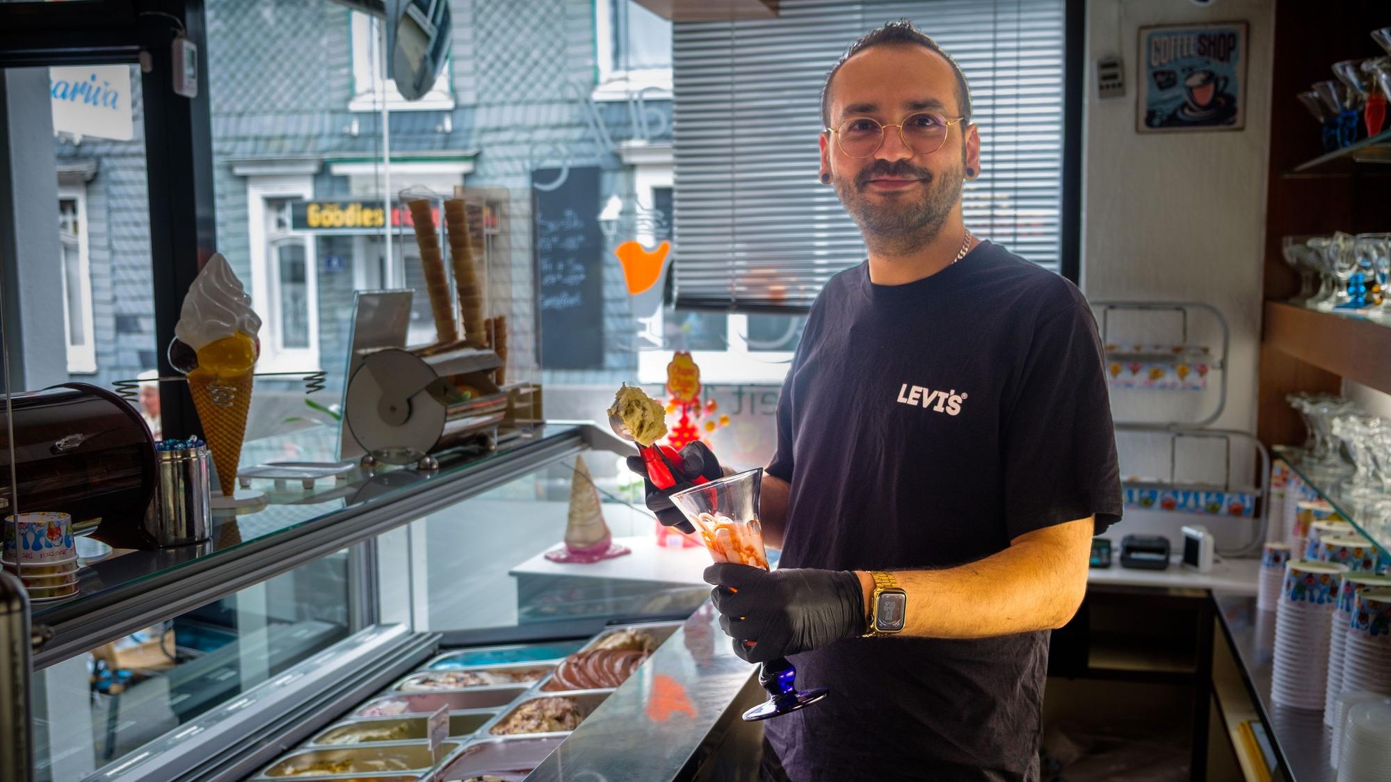 Anselmo Vetturini füllt in seiner Eisdiele an der Theke einen Eisbecher.