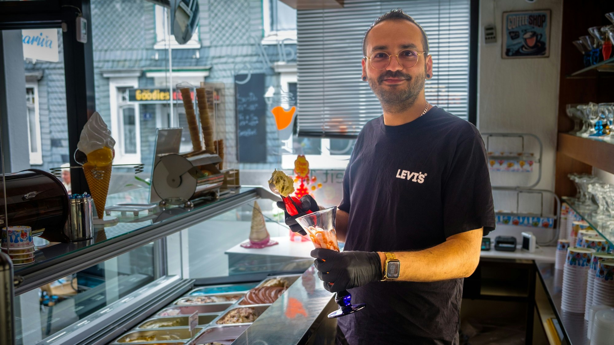 Anselmo Vetturini füllt in seiner Eisdiele an der Theke einen Eisbecher.