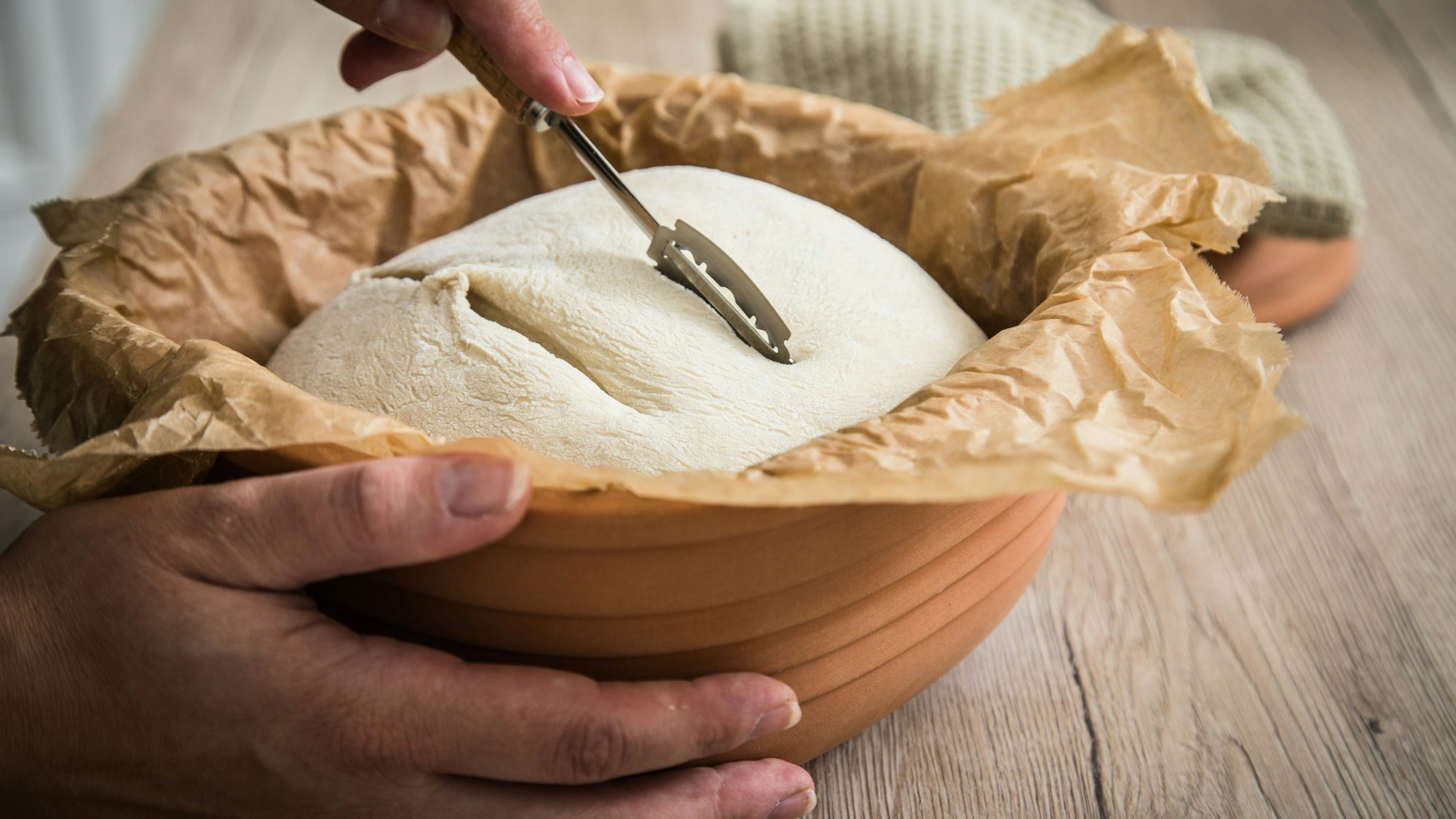 Sauerteig für Weizenbrot kann im Römertopf gebacken werden und wird vor dem Backen eingeschnitten.