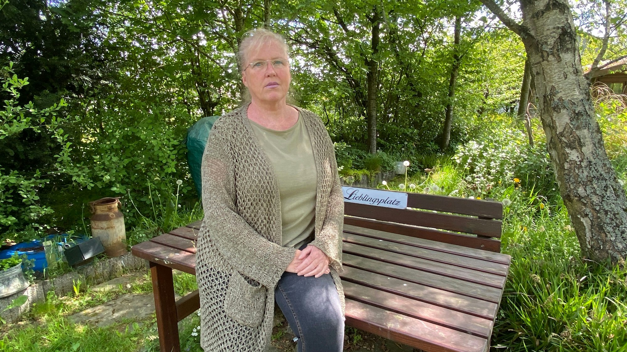 Sylvia Matuschek steht vor einer Sitzbank mit der Aufschrift „Lieblingsplatz“.