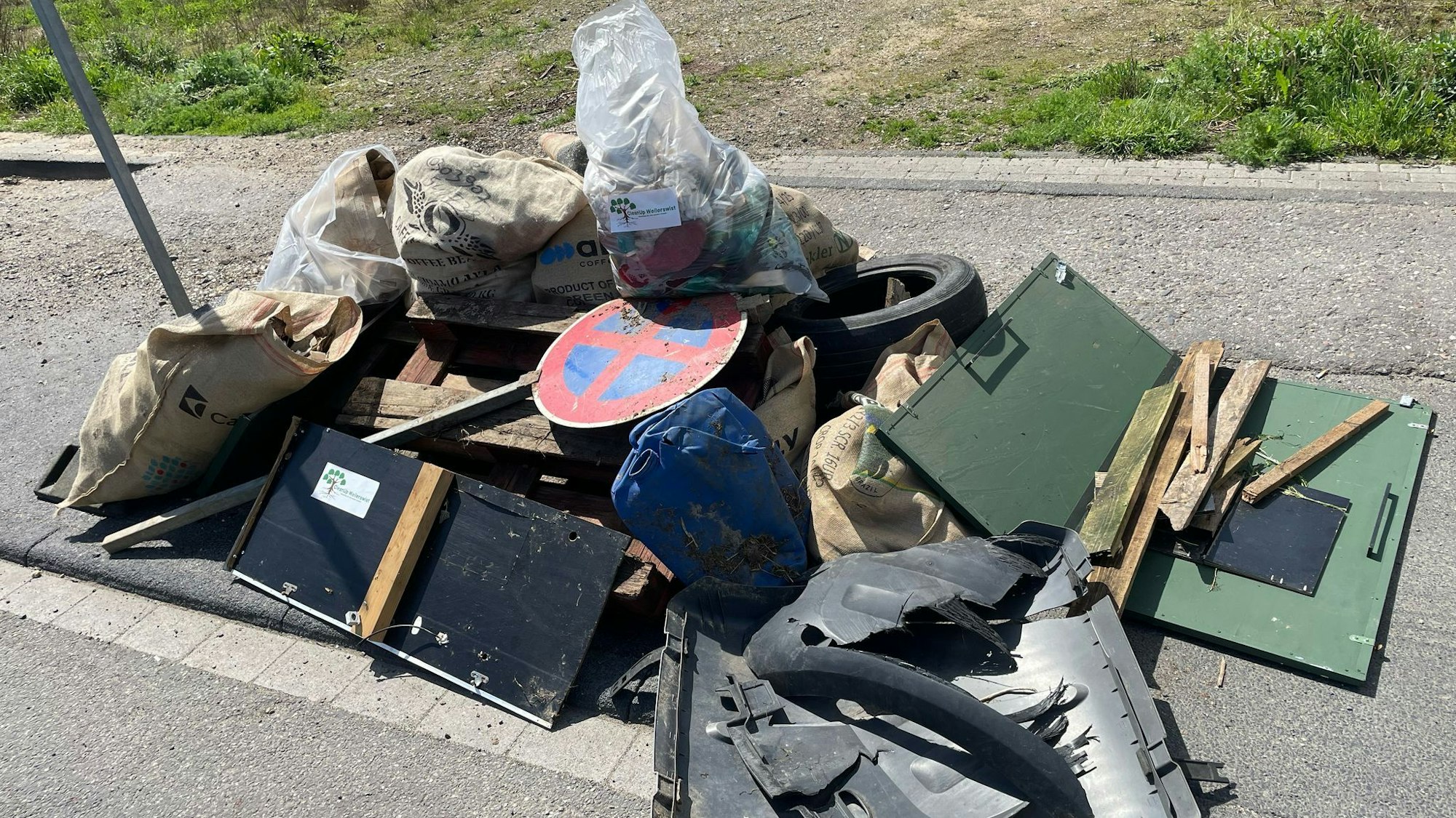 Unter anderem Schrankteile, Paletten und ein Straßenschild liegen auf einem Haufen.