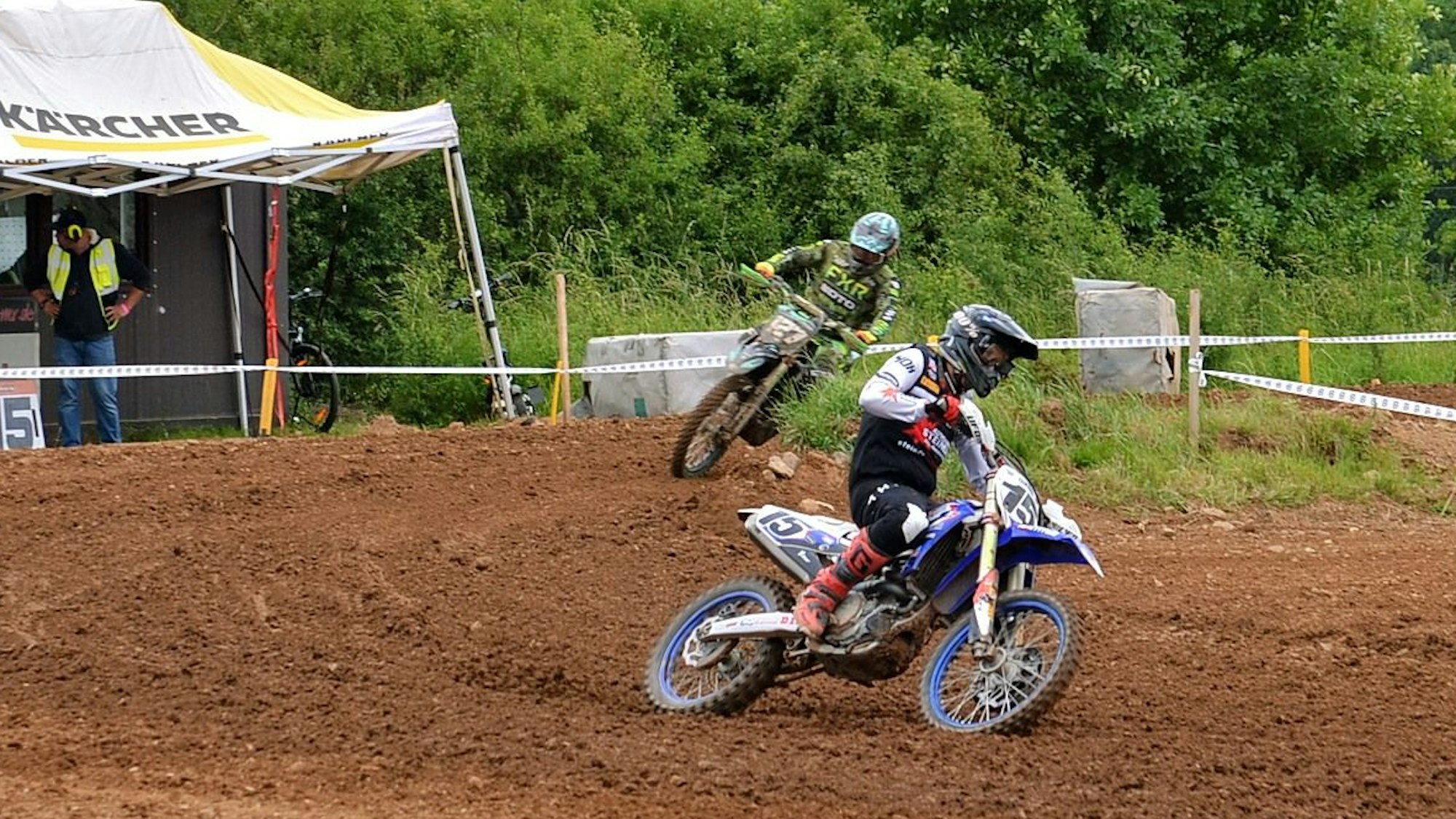 Zwei Wißkirchener Motocross-Fahrer befinden sich hintereinander in einer Kurve.