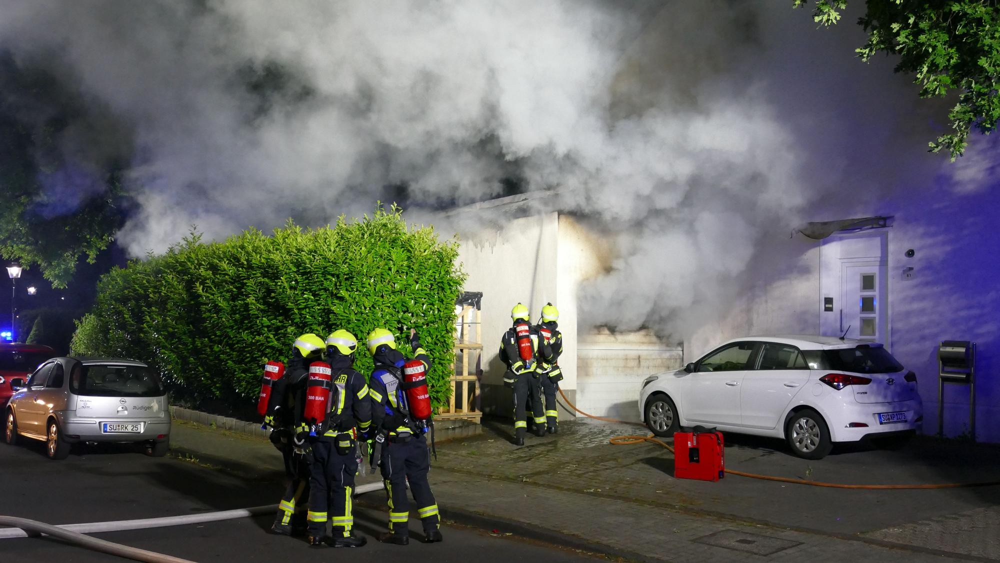 Die Garage stand in Flammen, dichter Rauch quoll hervor. Das Auto und die Hauswand wurden beschädigt. Garage stand in Flammen.
