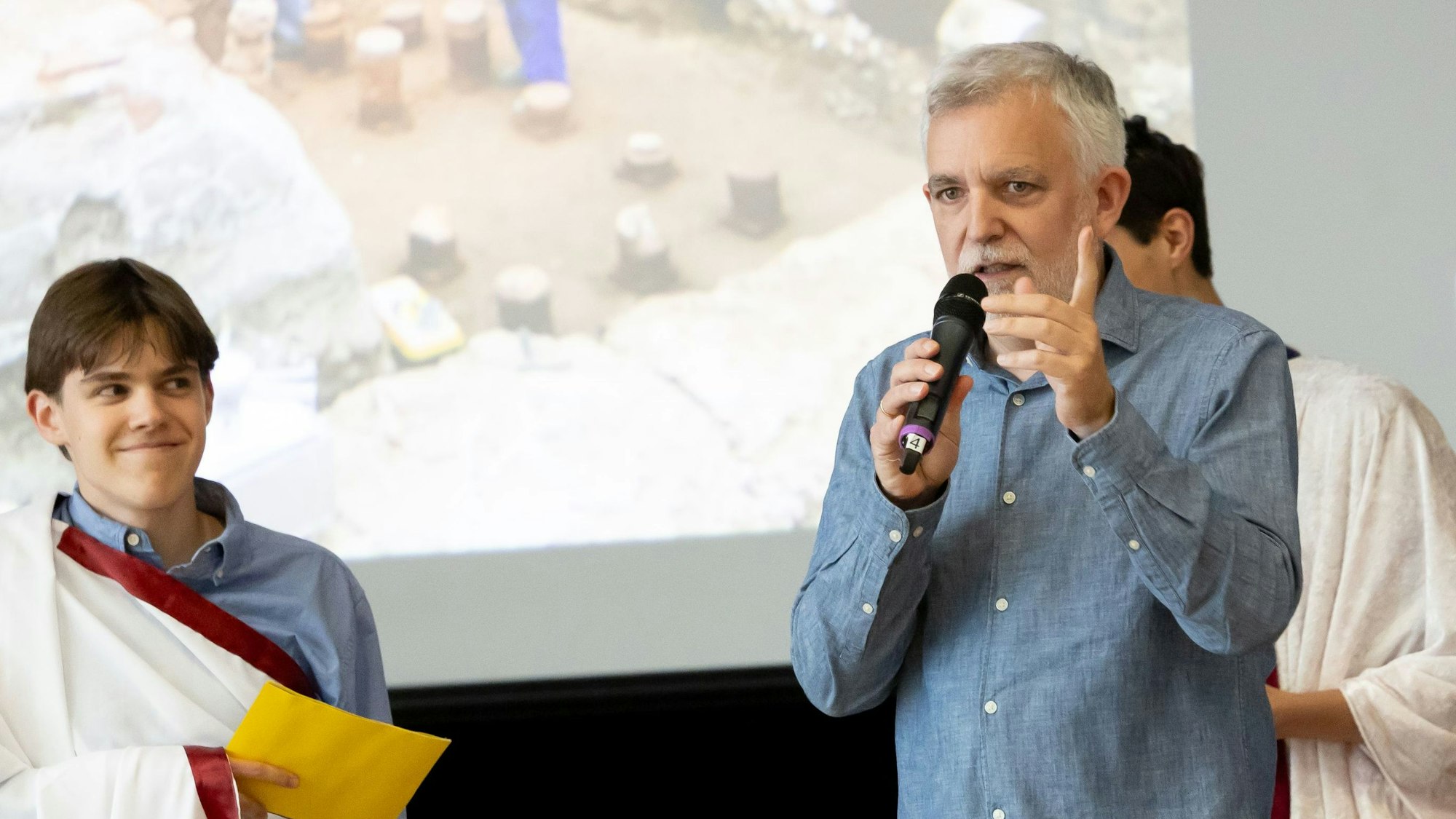 Ein Mann mit Mikrofon und ein Schüler.