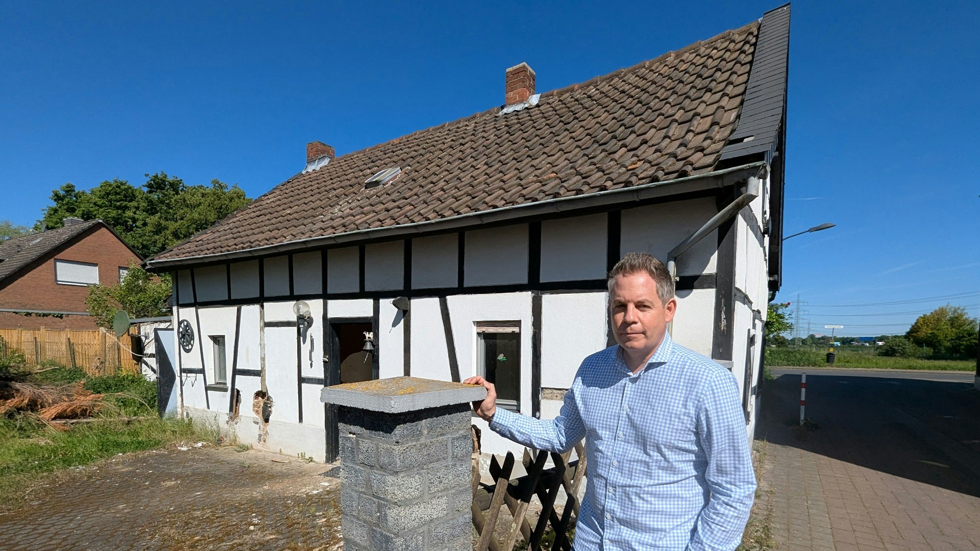 Das Foto zeigt den Sohn der Eigentümerin vor dem kleinen Fachwerkhaus in Sielsdorf.