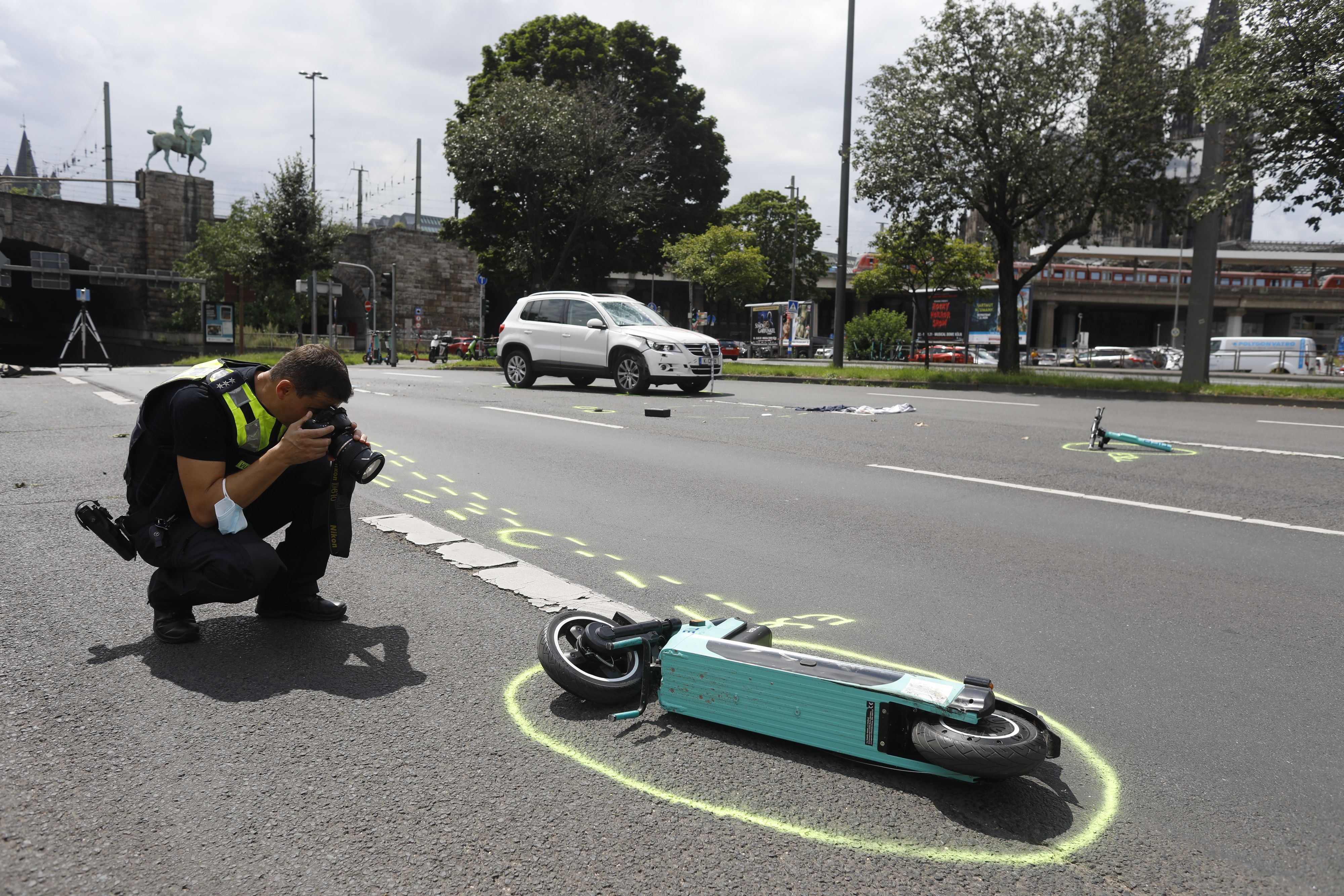 Das Bild zeigt einen Polizeibeamten, der einen E-Scooter fotografiert.