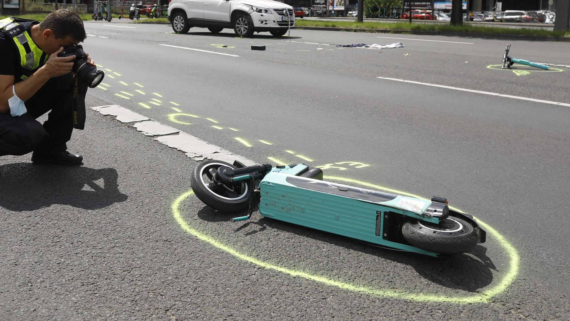 Das Bild zeigt einen Polizeibeamten, der einen E-Scooter fotografiert.