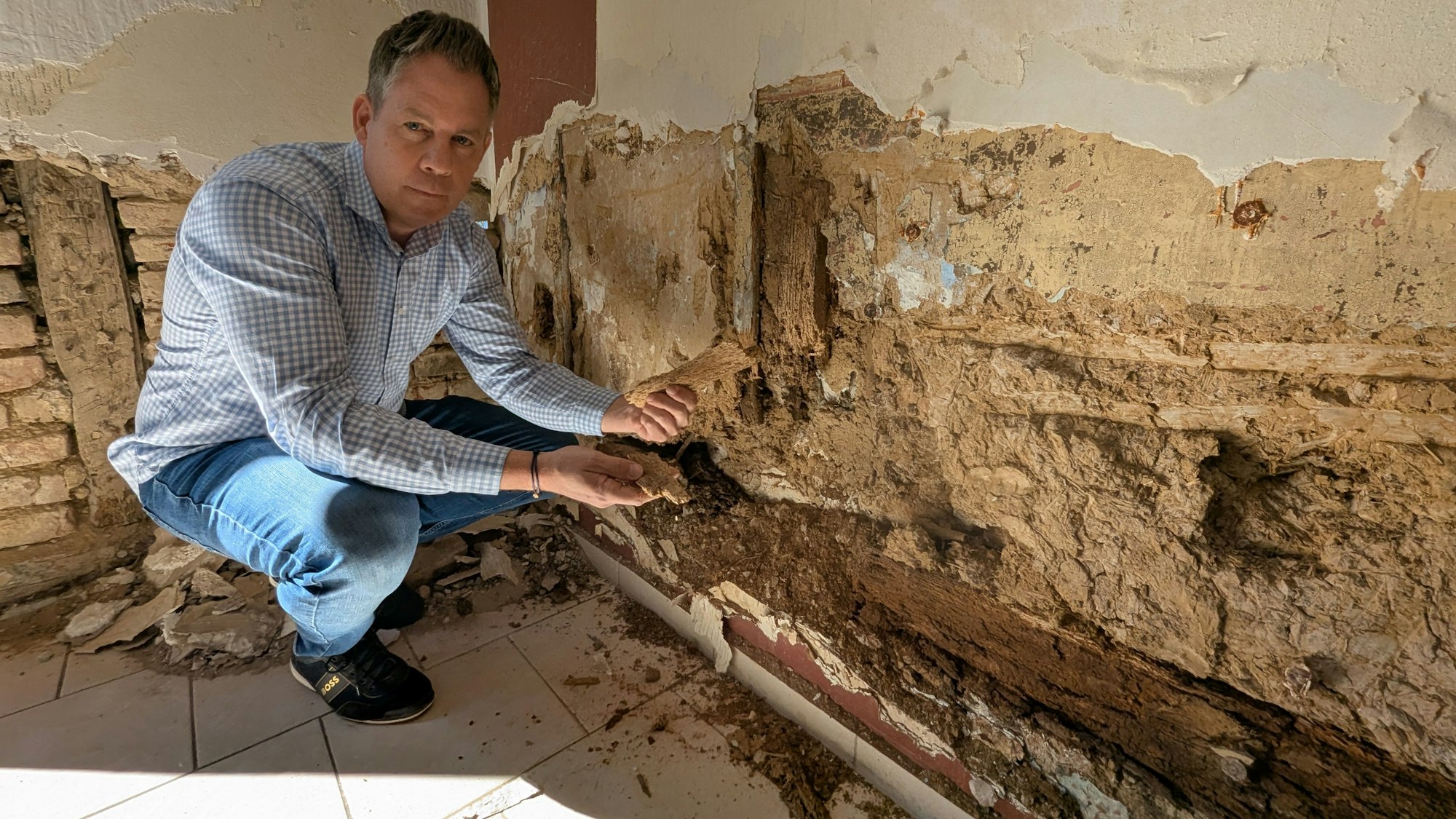 Das Foto zeigt Marcel Pohl vor einer aufgebrochenen Wand.