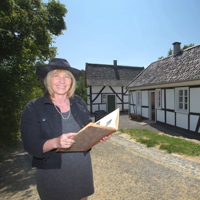Das Foto zeigt die beiden Kleinsthäuser aus Hilden, davor steht Petra Dittmar.
