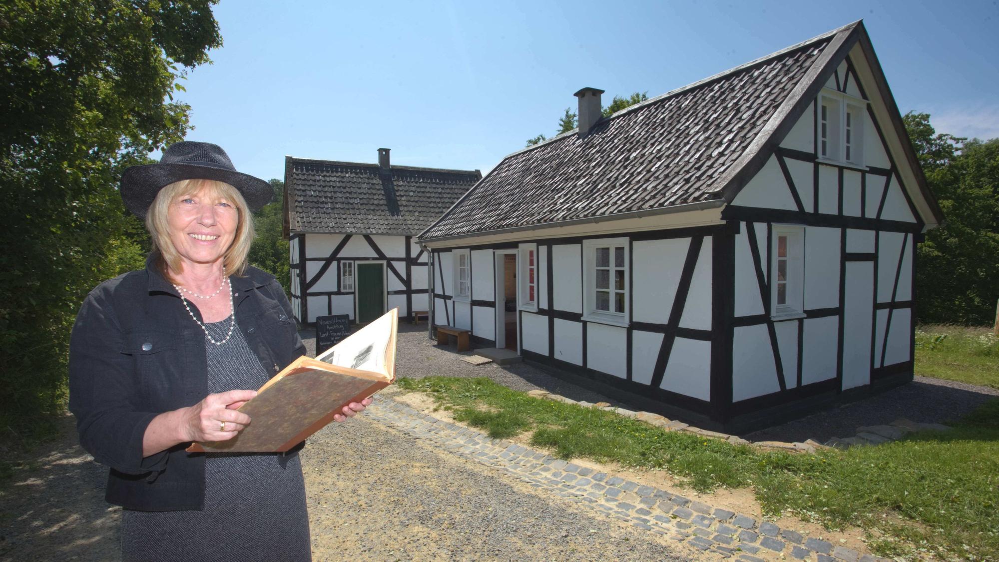 Das Foto zeigt die beiden Kleinsthäuser aus Hilden, davor steht Petra Dittmar.
