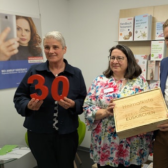 Die Vertreterinnen der Verbraucherzentrale und Markus Ramers stehen nebeneinander. Ramers hält eine Geschenkkiste in den Händen.