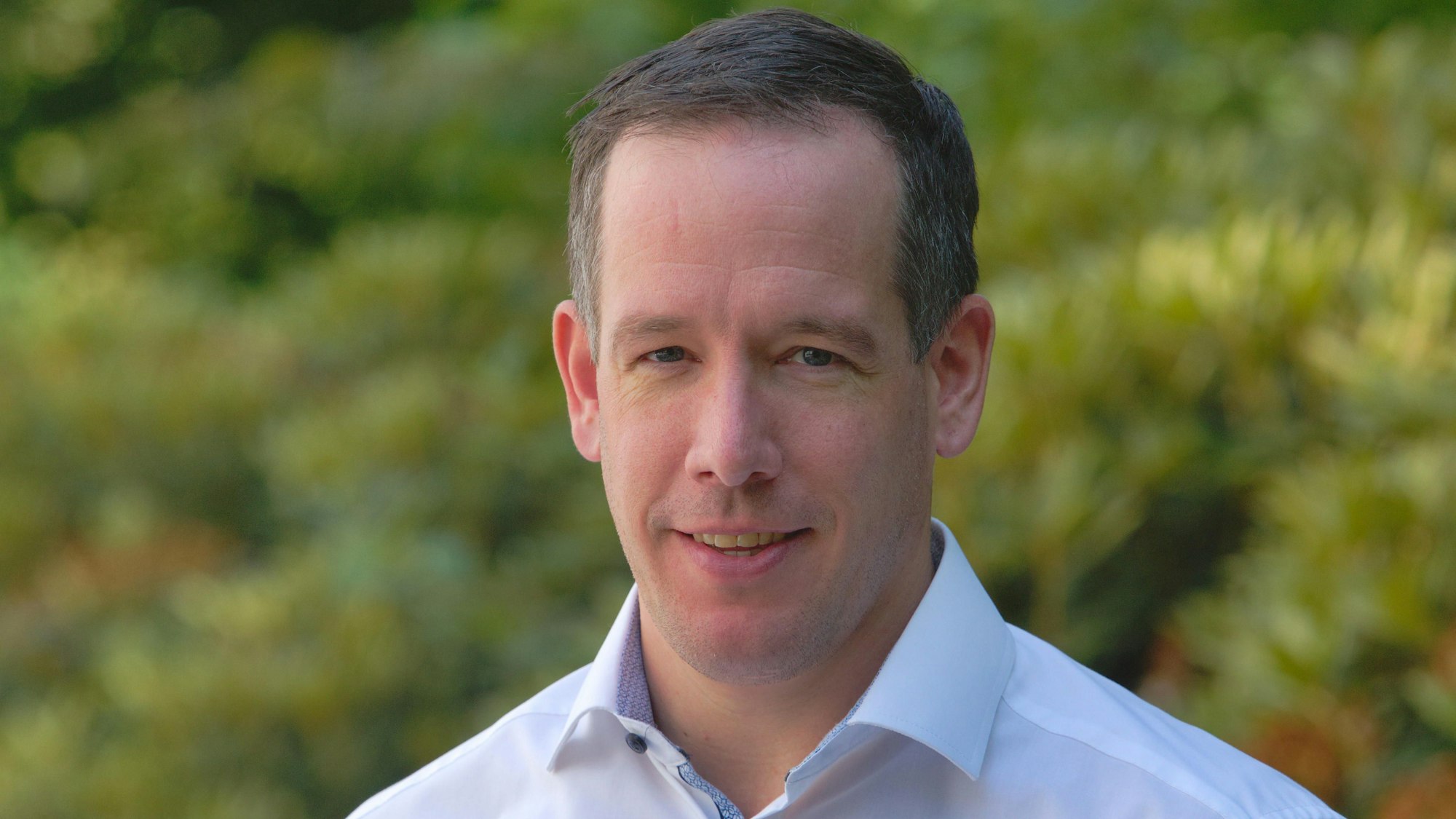 Ein junger Mann im blauen Oberhemd.