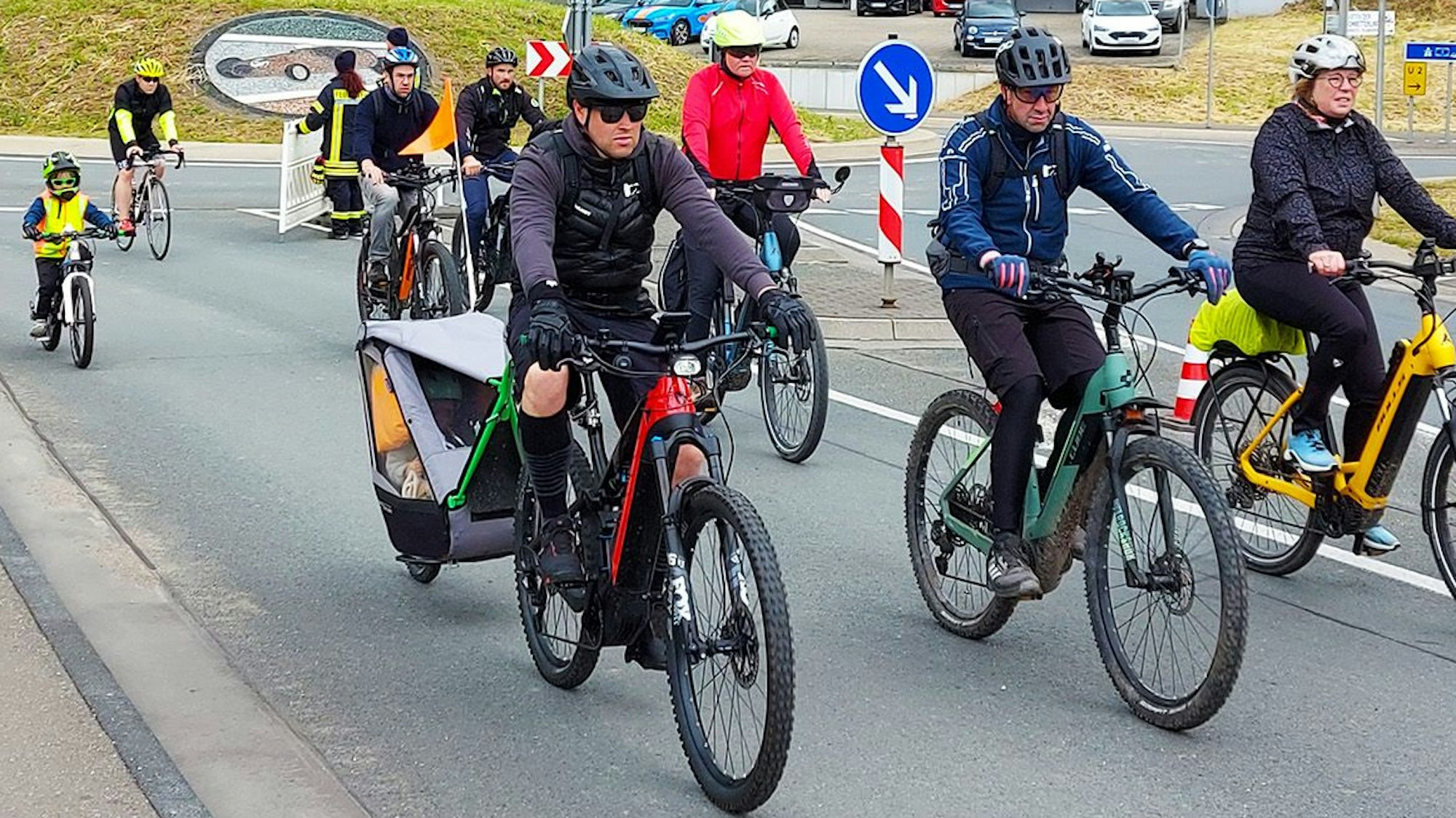 Mehrere Fahrradfahrer kommen aus einem Kreisel gefahren.