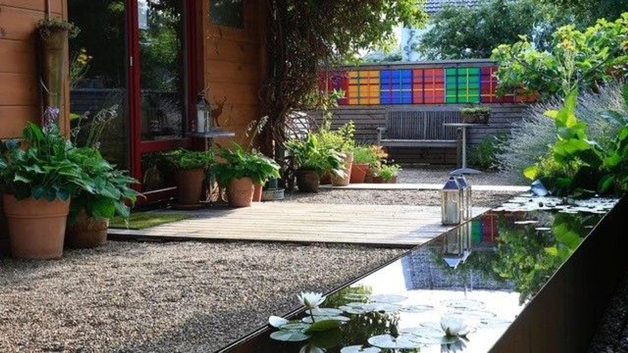 Eine Terrasse bestehend aus Kies und Holz gehört mit zum Garten.