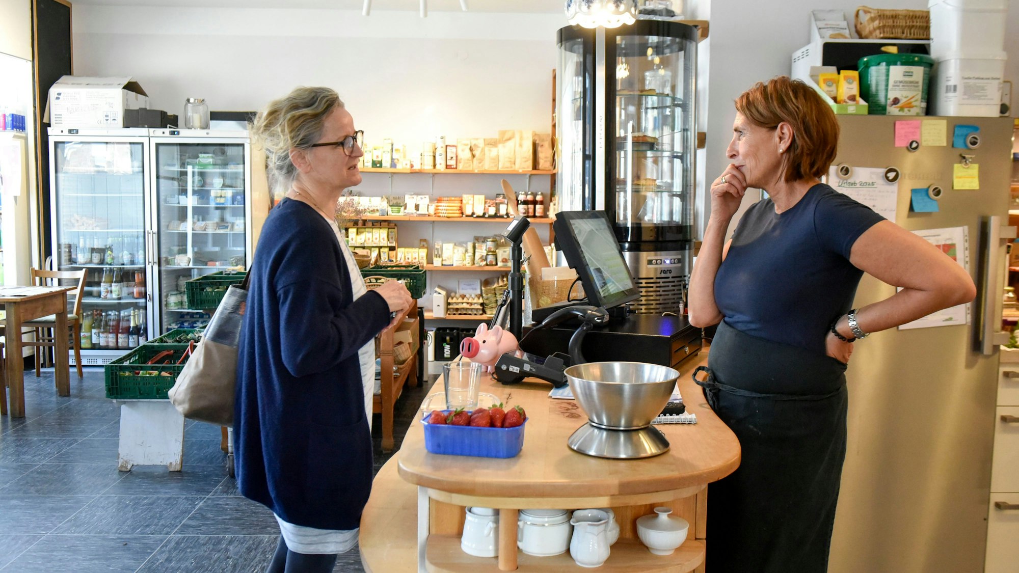 Das Foto zeigt zwei Frauen in einem Laden beim Plaudern.