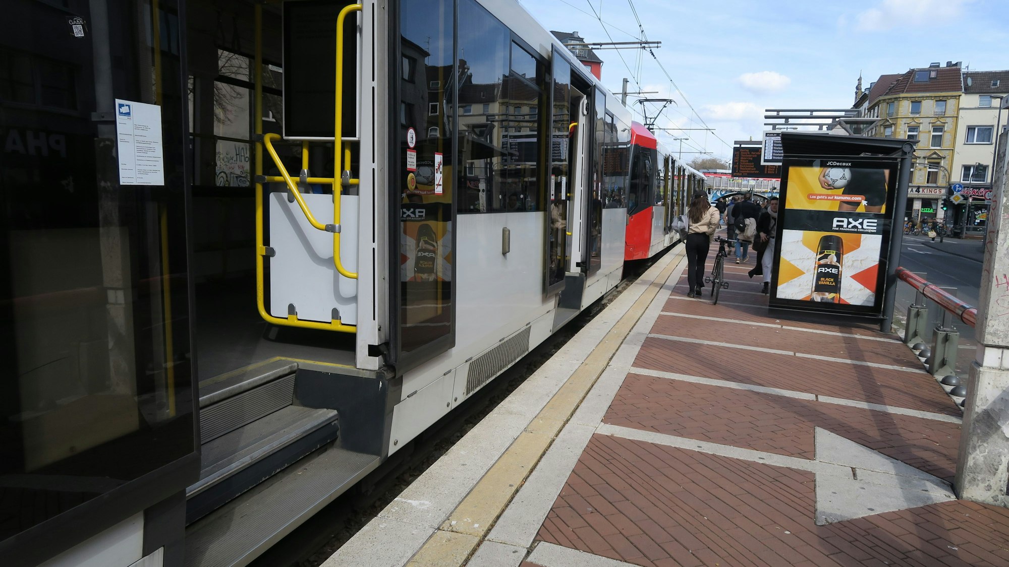 An einem Bahnsteig der KVB hält eine Straßenbahn, die Türen sind geöffnet.