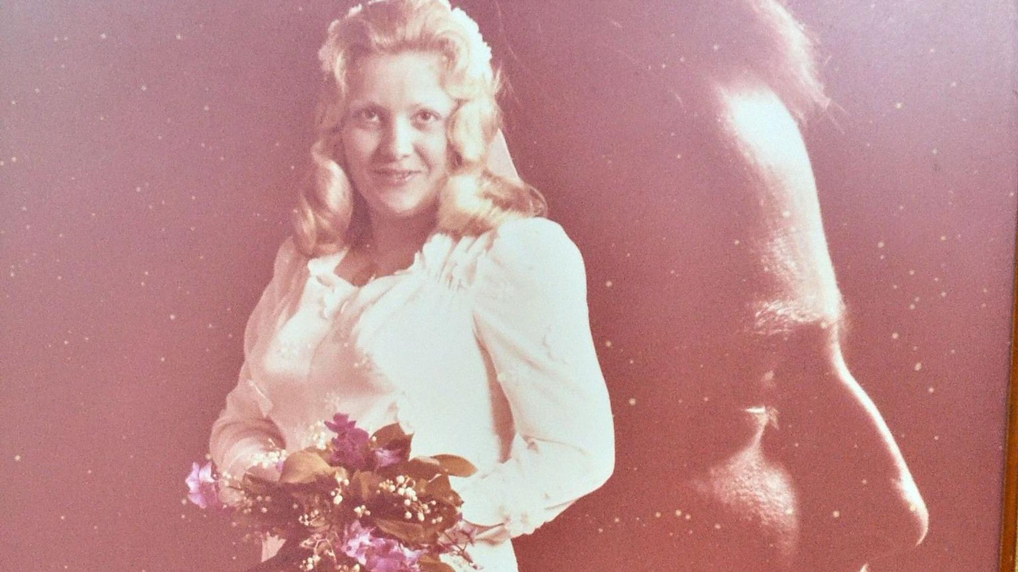 Angelika Bolz im weißen Hochzeitskleid, dahinter ist der Kopf von Heinz Dieter Bolz kunstvoll in das Bild montiert worden.