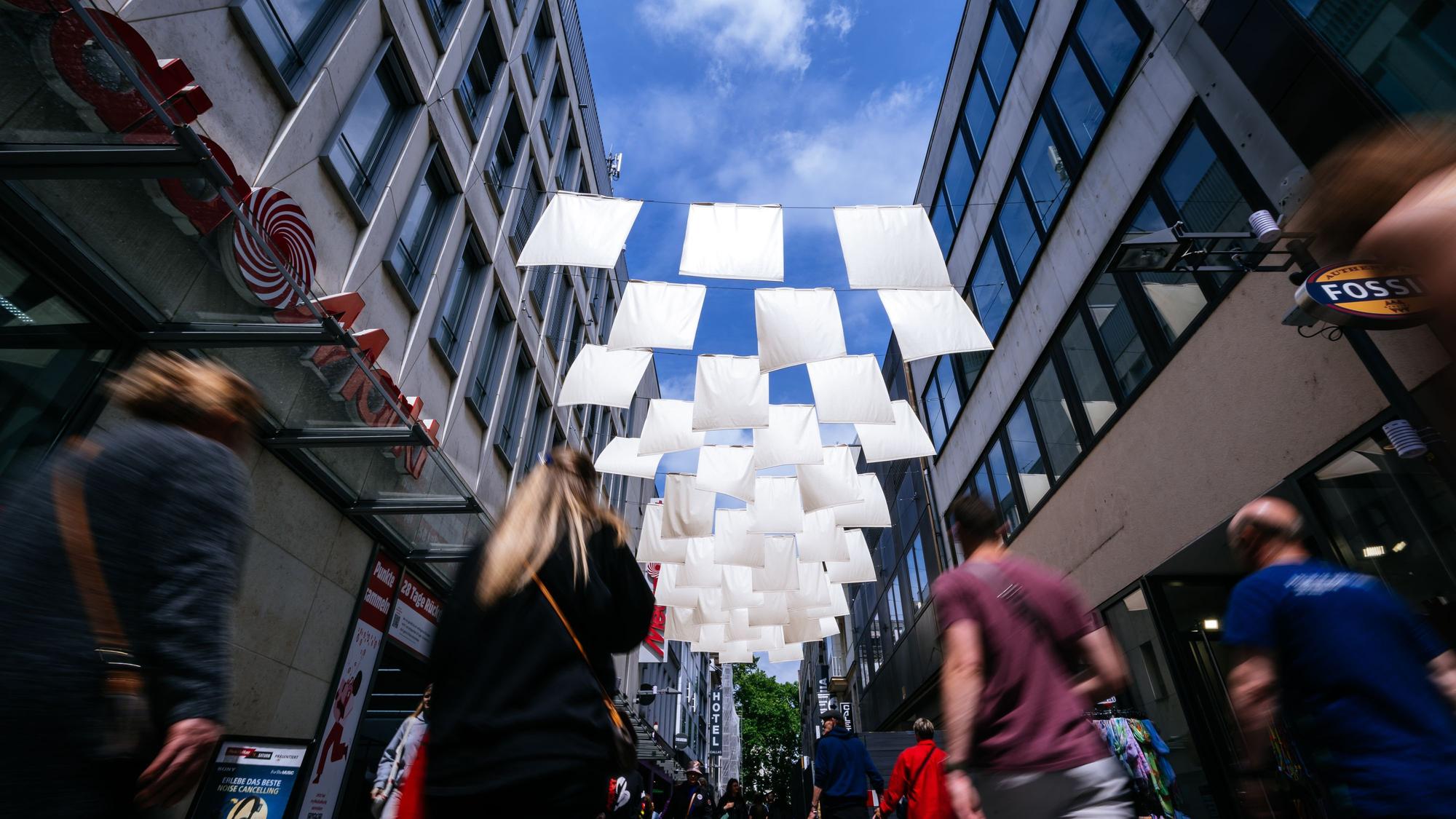 Damit Passanten im Sommer „nicht heißlaufen“ hängen in der Hohe Straße Sonnensegel. Die Uni Köln begleitet das Projekt.