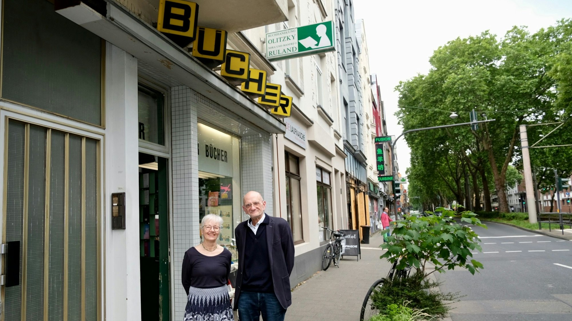 Eine Frau und ein Mann stehen vor Buchhandlung an der Luxemburger Straße.
