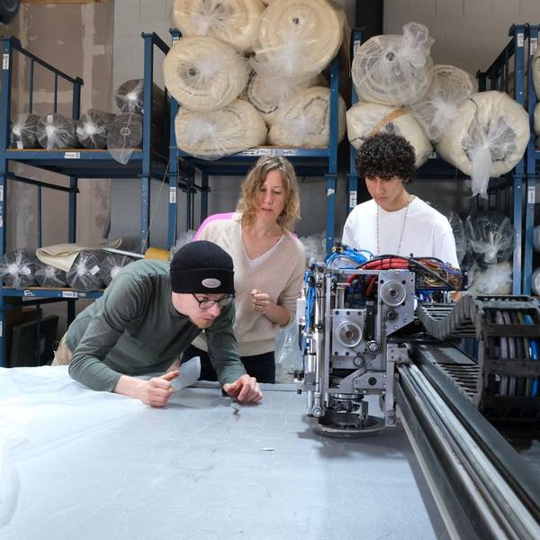 Bei Textilproduzent Marco Sheel (l.) prüfen Anna (M.) und Nevó Yona (r.) die Materialien für die Barfußschuhe.