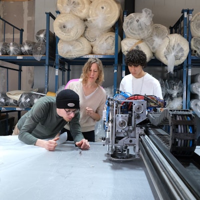 Bei Textilproduzent Marco Sheel (l.) prüfen Anna (M.) und Nevó Yona (r.) die Materialien für die Barfußschuhe.