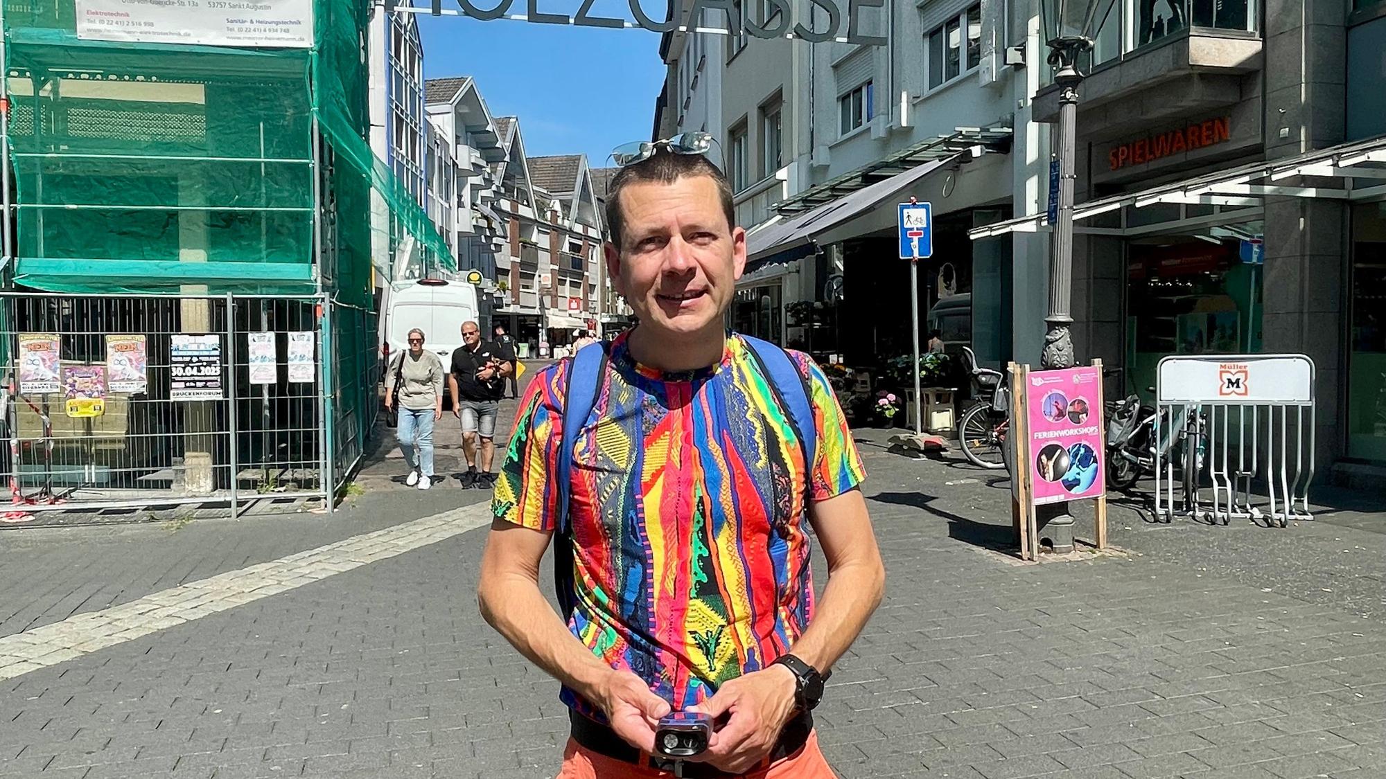 Meteorologe Karsten Brandt mit dem Hitzemesser unterwegs in Siegburg. In der Holzgasse hinter ihm staut sich die Hitze.