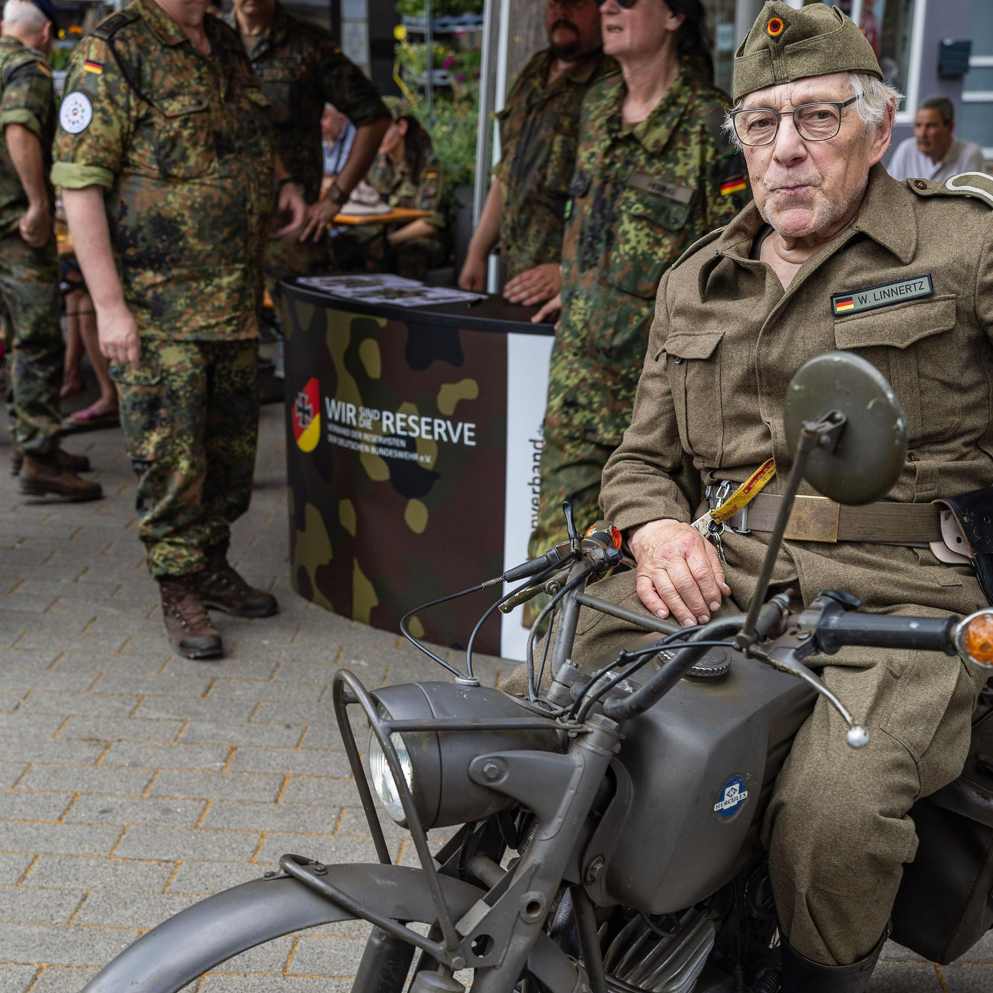 In einer historischen Uniform sitzt Walter Linnertz auf dem alten Bundeswehrmotorrad.