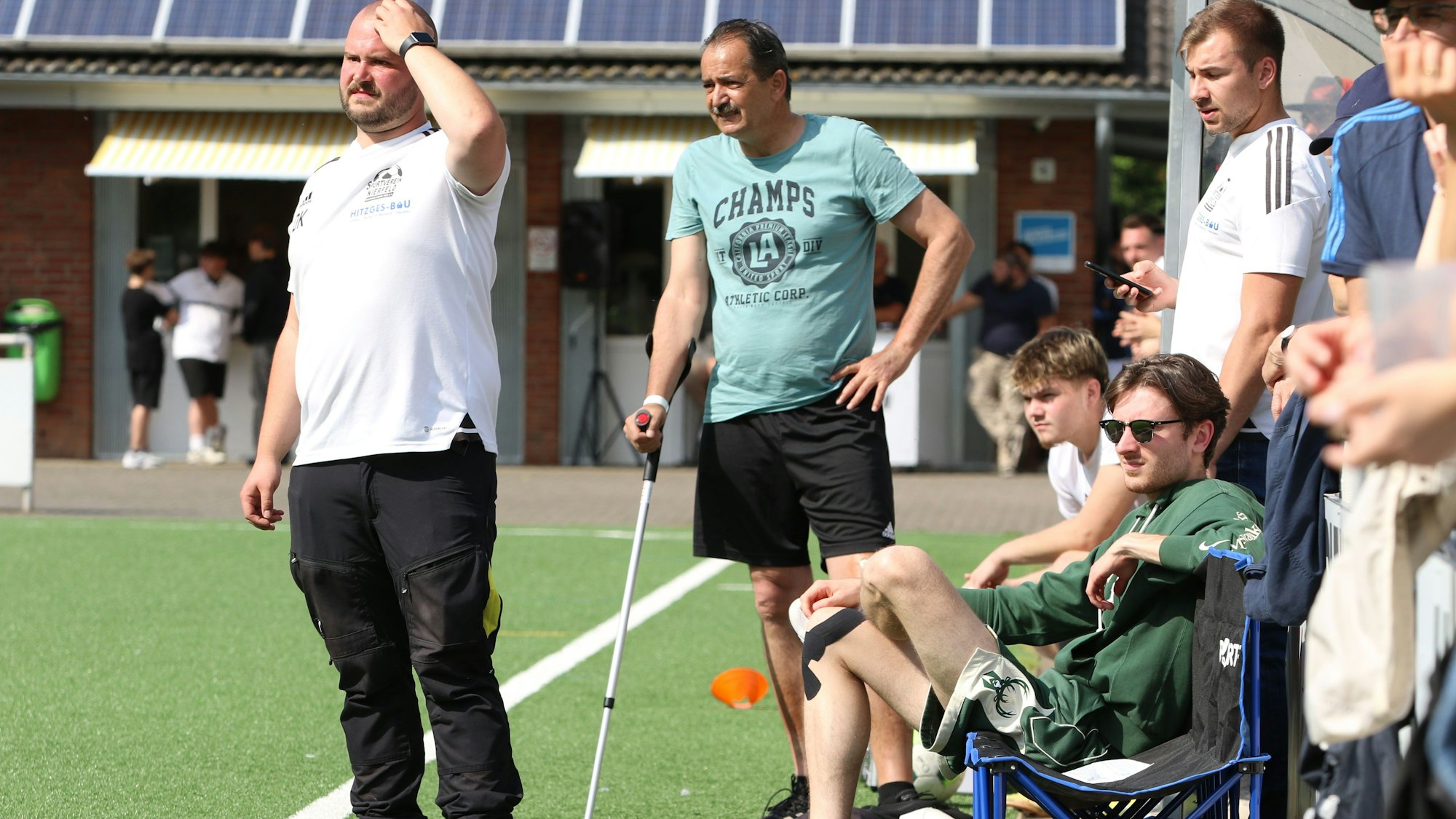 Das Bild zeigt den Coach, der mit einer Krücke am Spielfeldrand steht.