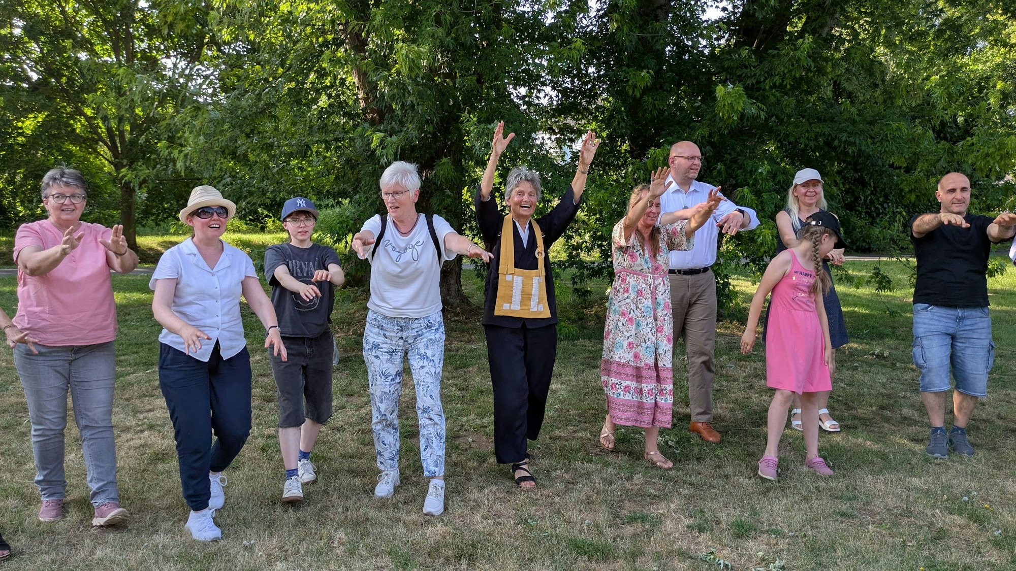 Mehrere Menschen tanzen nebeneinander.