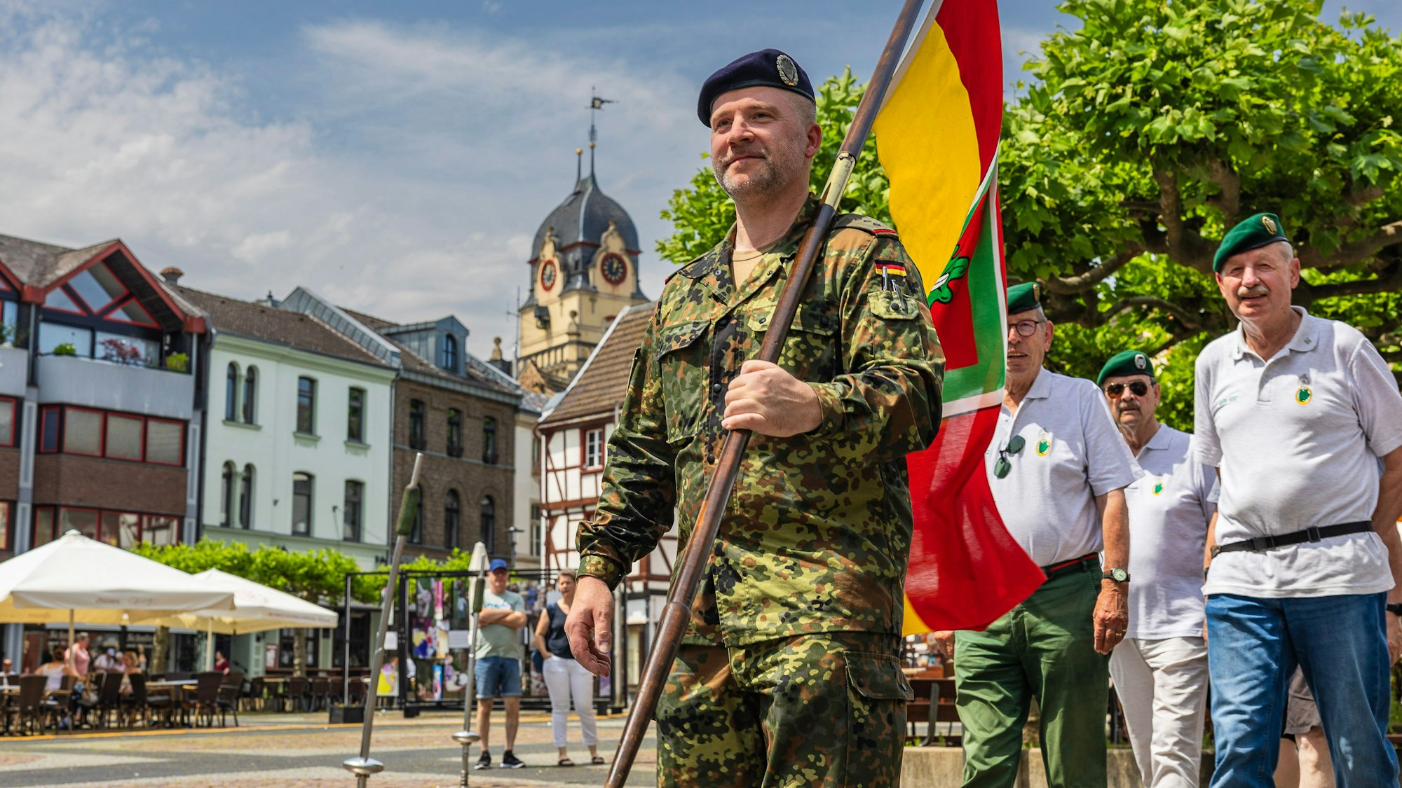 Mit einer Fahne voran zieht die Kameradschaft ehemaliger Euskirchener Jäger über den Alten Markt mit dem alten Rathaus im Hintergrund.