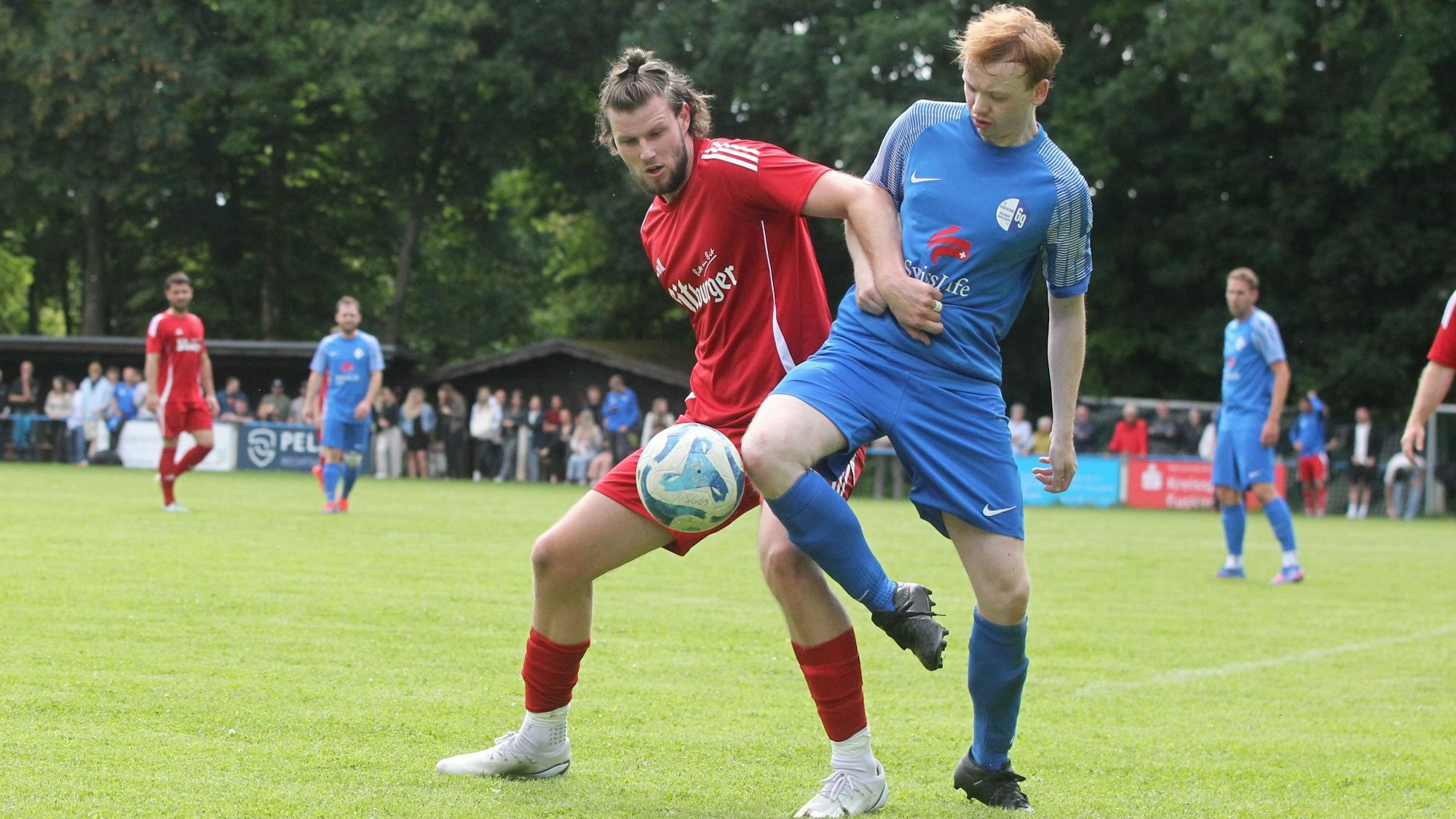 Das Bild zeigt zwei Fußballer im Zweikampf.