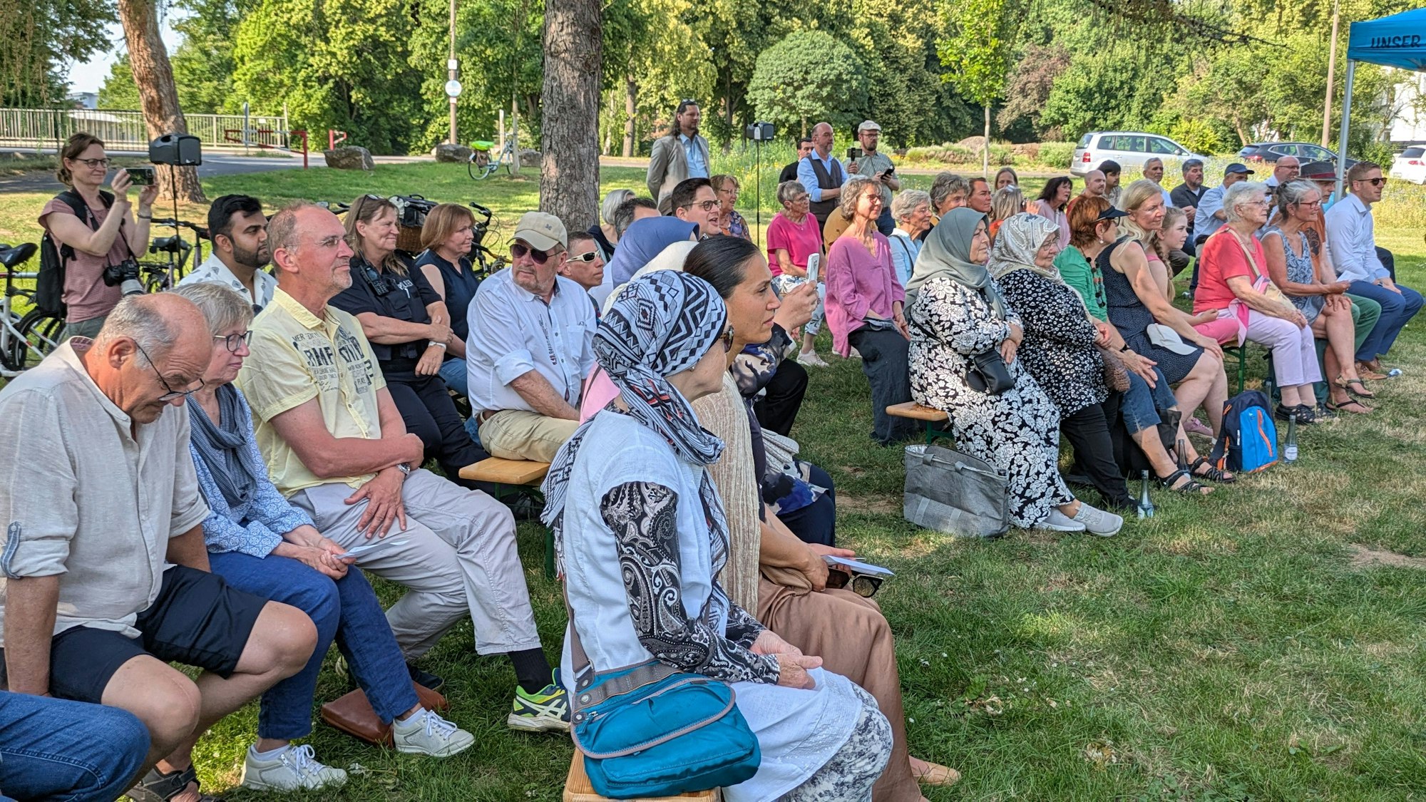 Die Besucher sitzen auf Bänken und lauschen den Gebeten und Vorträgen.