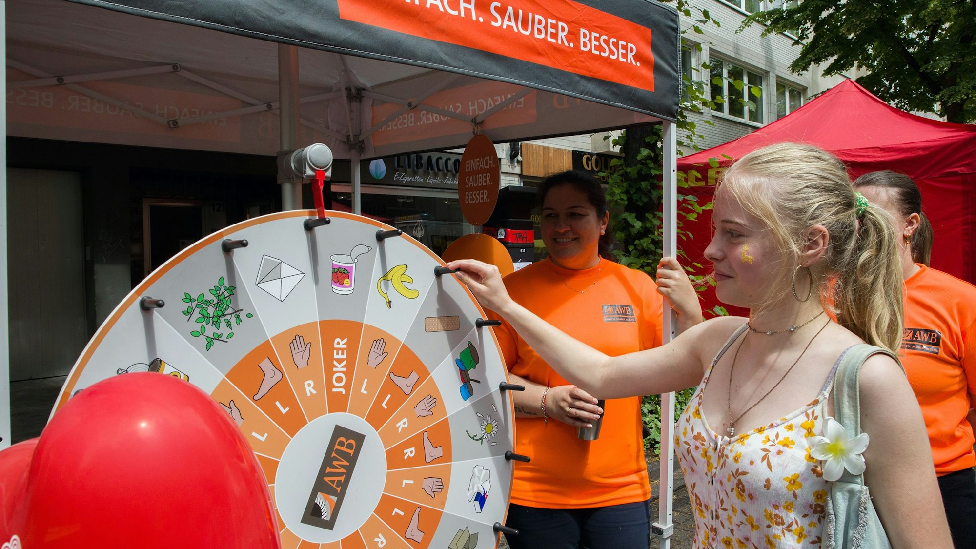 Eine junge Frau mit blondem Haarzopf dreht ein Glücksrad.