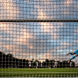 Das Bild zeigt einen Torwart, der mit einer Parade den Ball hält.