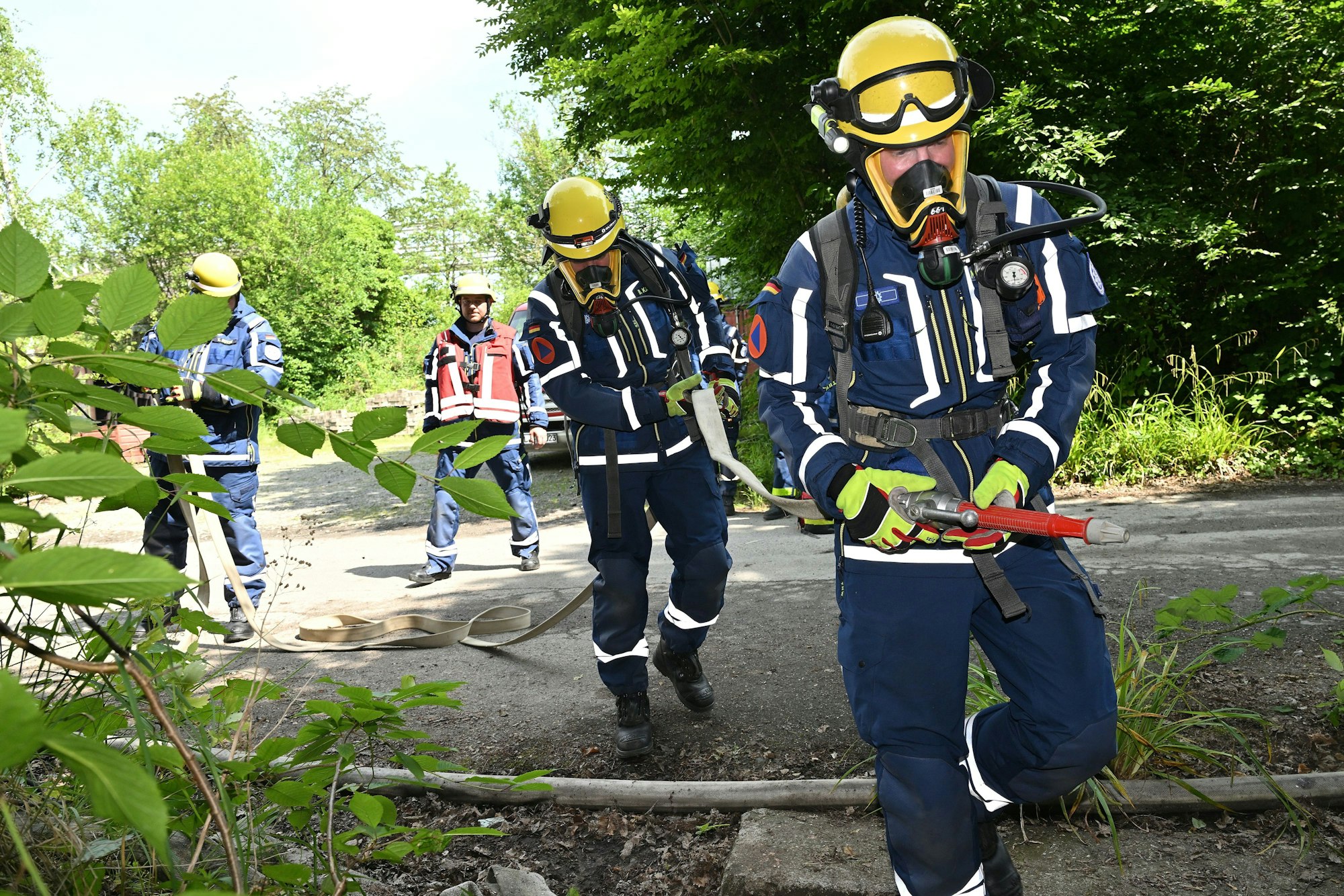 Ein Trupp von THWlern startet bei der Großübung der Feuerwehr Bergisch Gladbach einen Löschangriff.