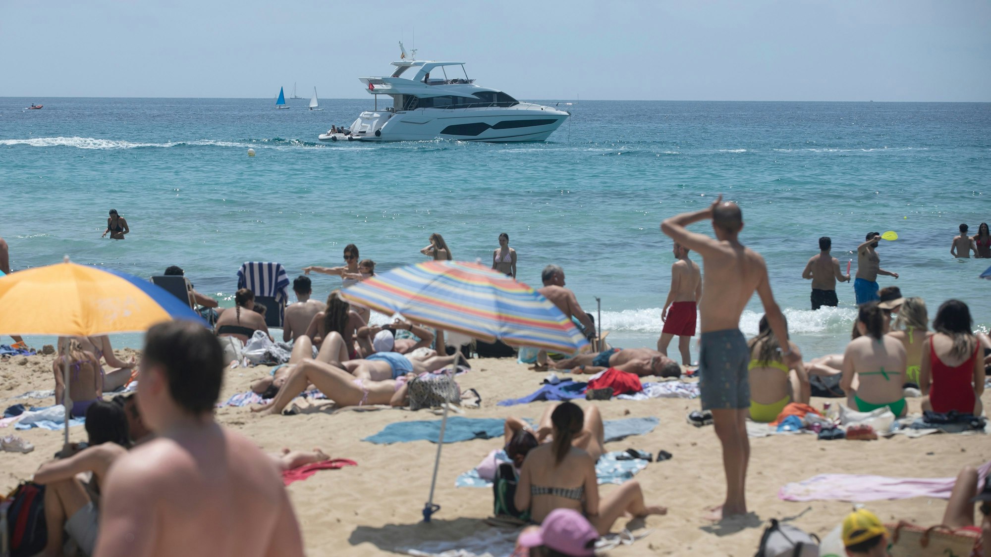 18.05.2025, Spanien, Palma: An einem Tag mit Temperaturen um die 29 Grad, etwas höher als für diese Jahreszeit üblich, sonnen sich die Menschen am Strand von Cala Major in Palma. Foto: Clara Margais/dpa +++ dpa-Bildfunk +++