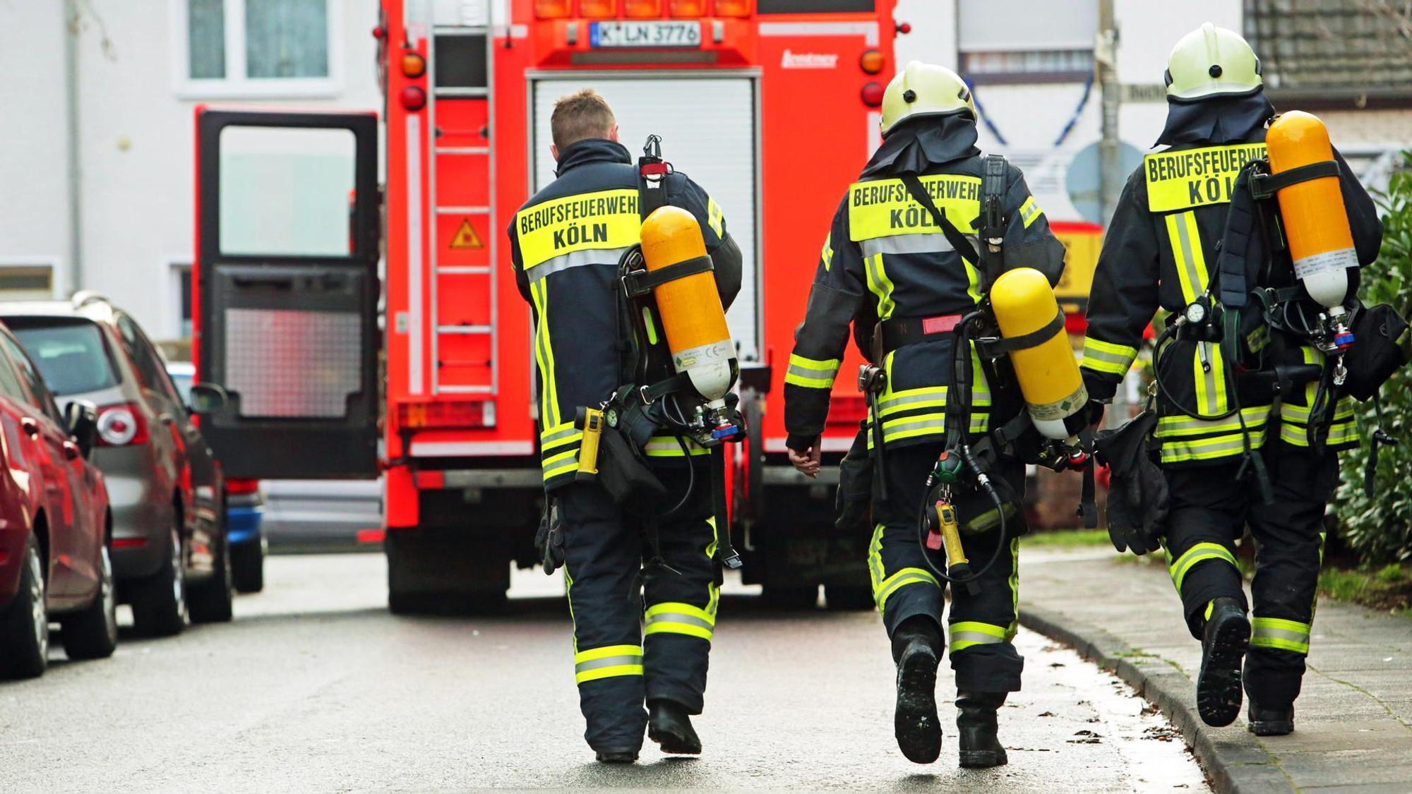 Feuerwehrmänner laufen auf ein Löschfahrzeug zu.