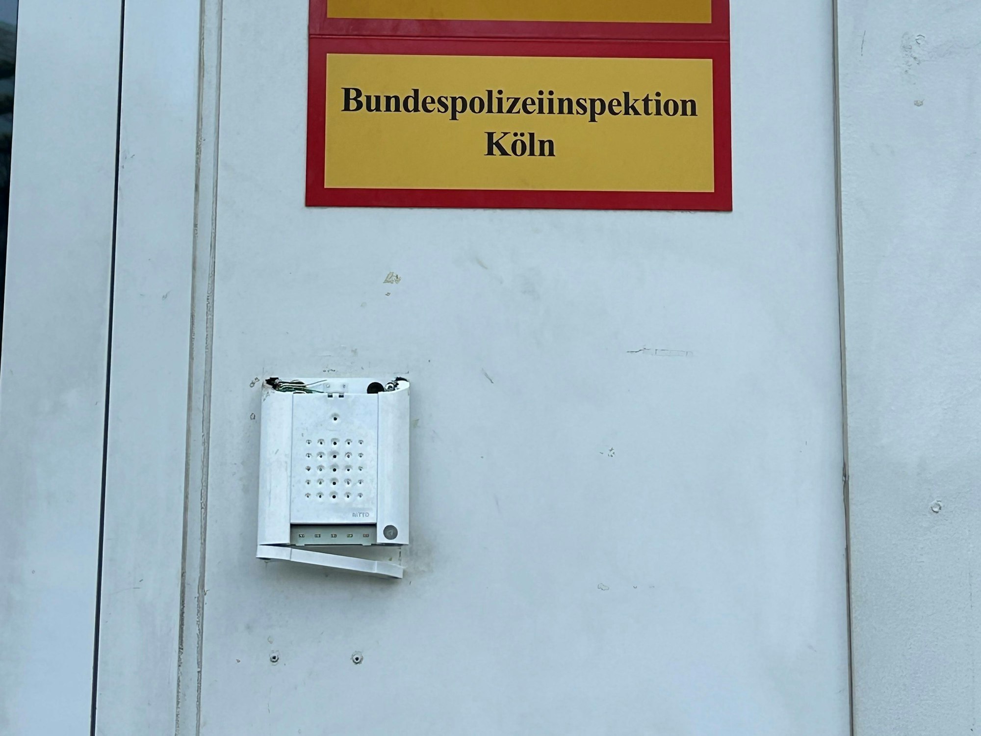 Die stark beschädigte Klingel an der Containerwache.