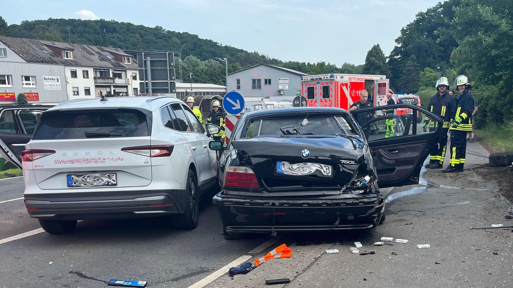 Zwei Unfallautos stehen in Kürten-Broich nebeneinander. Im Hintergrund sind Feuerwehrleute und Rettungsdienst zu sehen.