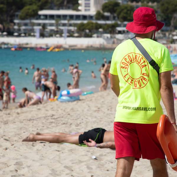 Ein Rettungsschwimmer geht am Strand von Magaluf auf Mallorca entlang.