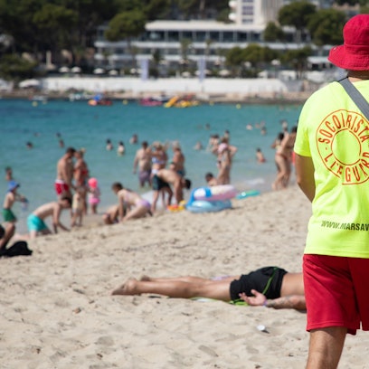Ein Rettungsschwimmer geht am Strand von Magaluf auf Mallorca entlang.