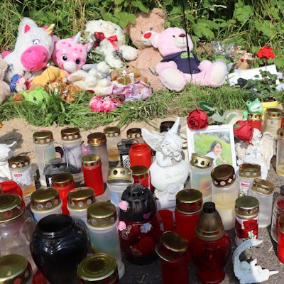 Auf dem Bild ist eine Gedenkstätte mit vielen Kerzen, Stofftieren und Erinnerungsfotos zu sehen.