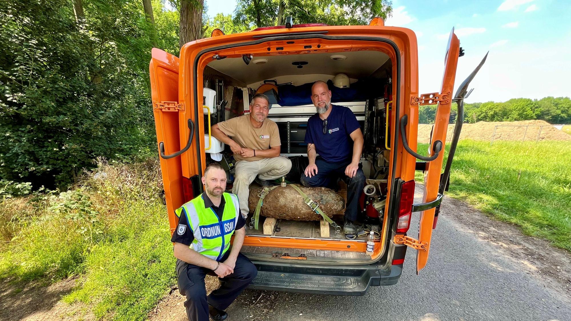 Das Foto zeigt von links nach rechts: Sebastian Baals (Einsatzleitung Ordnungsamt), Marcel Biewald (KBD) und Christoph Wassenberg (KBD) mit der entschärften Bombe in Köln-Rodenkirchen. Foto: Stadt Köln