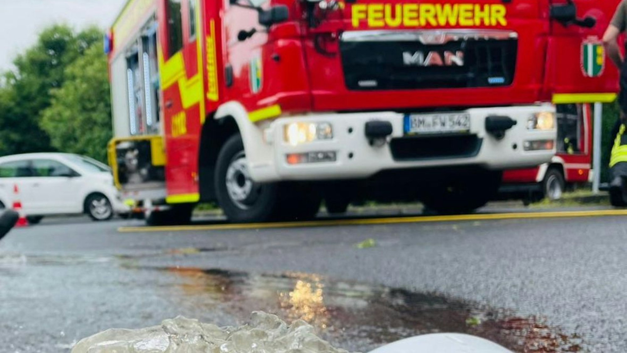 Zu sehen ein Feuerwehrauto vor einer Straße.