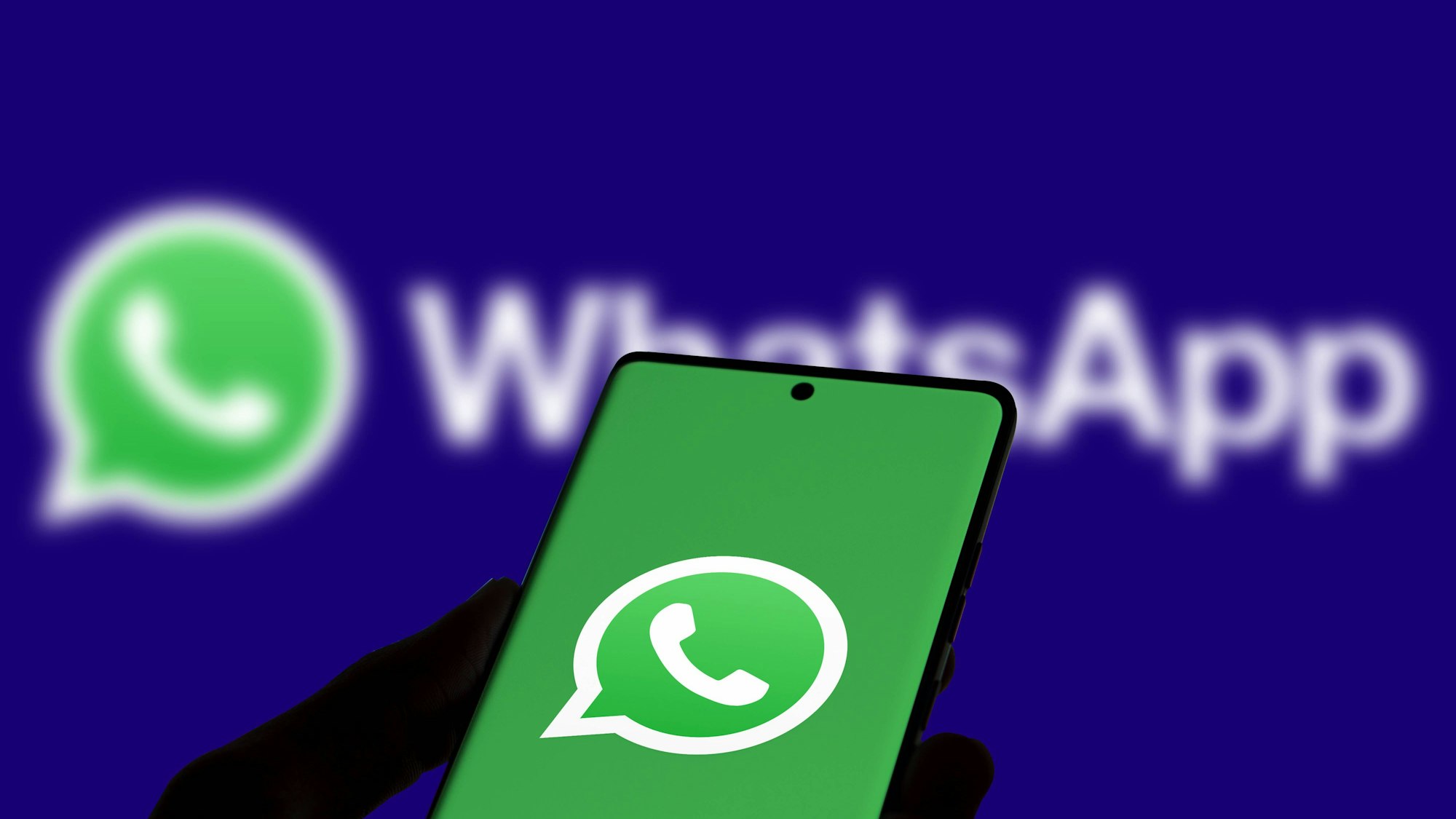 Ein Smartphone-Bildschirm zeigt die App von WhatsApp sowie das WhatsApp-Logo. (Symbolbild)