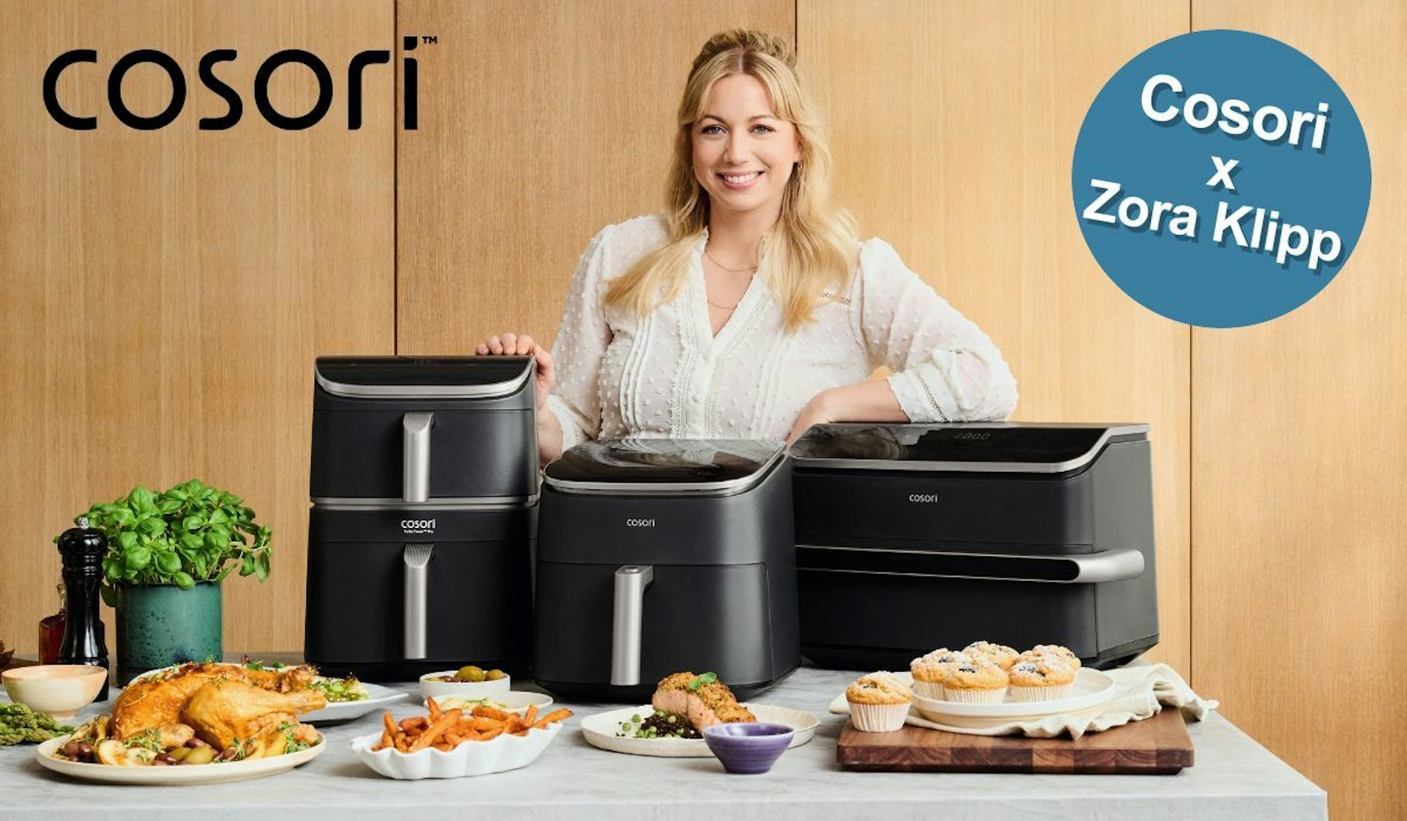 Zora Klipp hinter Tisch mit Cosori Airfryer und Essen.