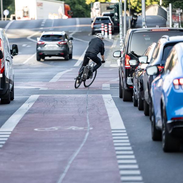 Eine Person fährt mit dem Fahrrad über einen Fahrrad-Schutzstreifen.